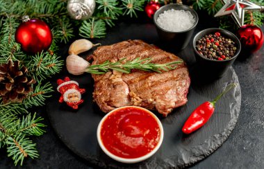 Siyah arka planda baharatlı ve sebzeli ızgara biftek. en üstteki görünüm.