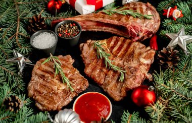 Biberiyeli ızgara biftek ve siyah arka planda baharatlar.