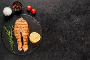 Baharatlı çiğ balık ve siyah taş arka planda bitkiler. en üstteki görünüm.