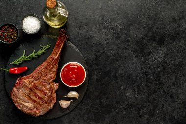 Baharatlı ızgara biftek ve siyah arka planda biberiye.