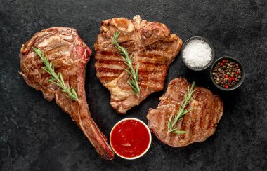 Baharatlı ızgara biftek ve siyah taş kaplama otlar. en üstteki görünüm.