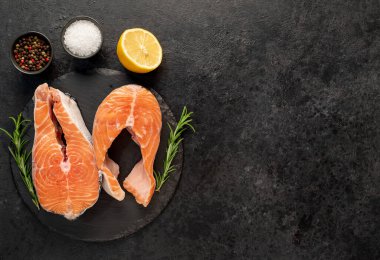 Baharatlı taze somon filetosu ve siyah taş kaplama otlar. en üstteki görünüm.