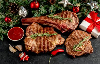 Siyah arka planda baharatlı ve sebzeli ızgara et.