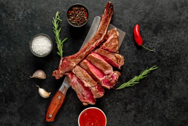 Baharatlı çiğ biftek ve siyah arka planda biberiye.