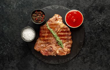 Baharatlı ızgara biftek ve siyah taş kaplama otlar. en üstteki görünüm.