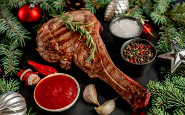 Baharatlı biftek ve ahşap masada sebze.