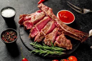 Biberiyeli çiğ biftek ve ahşap bir tahtada baharatlar..