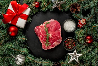 Siyah arka planda çiğ et ve baharatlar.