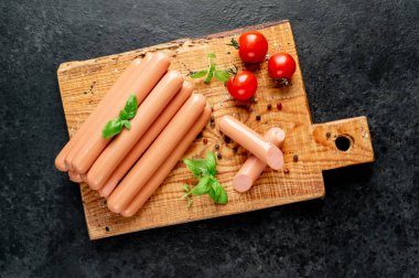 Baharatlı sosisler ve ahşap arka planda otlar.