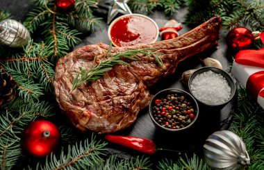 Biberiyeli ızgara biftek ve ahşap masada baharatlar.