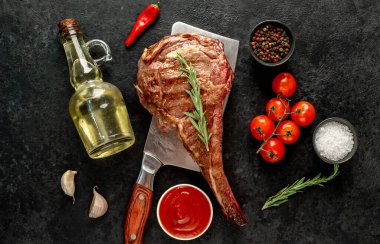 Baharatlı ızgara biftek ve siyah arka planda otlar.