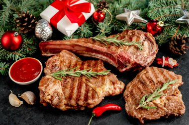 Siyah arka planda baharatlı ve sebzeli ızgara et.