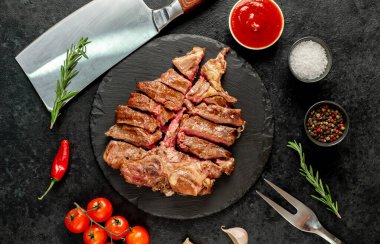 Ahşap bir tahtanın üzerinde baharatlı ve otlu ızgara et. en üstteki görünüm.