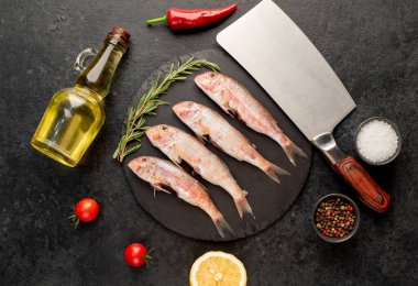 Siyah arka planda baharatlı çiğ balık