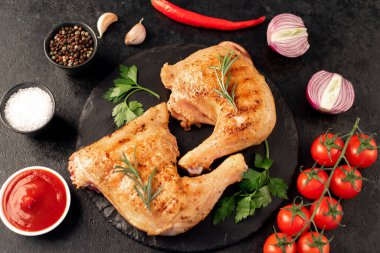 Kızarmış tavuk bacağı siyah masada. 