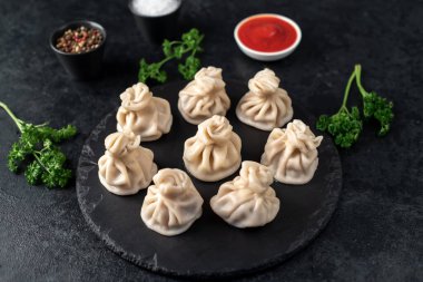 Lezzetli Gürcü khinkalileri siyah masada. 