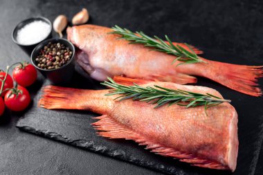 Masada malzemelerle kaplı kırmızı çiğ balıkların hazırlanması 