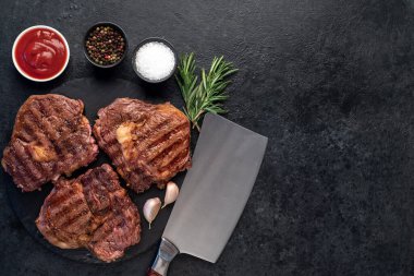 Biftek ve malzemelerle dolu ızgara bifteklerin üst görüntüsü.  