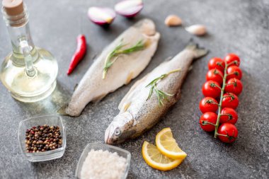 Koyu arkaplanda malzemeli çiğ alabalık.