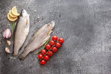 Koyu arkaplanda malzemeli çiğ alabalık.