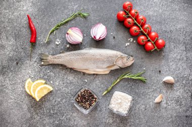 Koyu arkaplanda malzemeli çiğ alabalık.