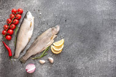 Koyu arkaplanda malzemeli çiğ alabalık.