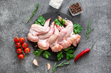 Siyah arka planda malzemeli çiğ tavuk kanadı.