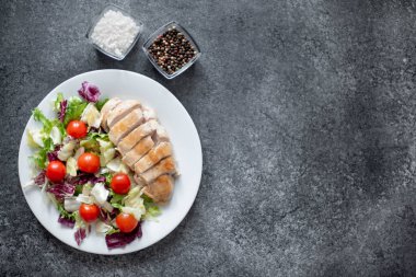 Kızarmış tavuk göğsü ve tabakta sebze salatası. 