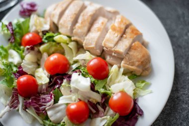Kızarmış tavuk göğsü ve tabakta sebze salatası. 