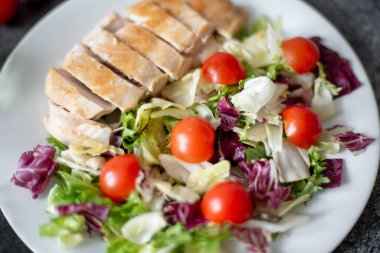 Kızarmış tavuk göğsü ve tabakta sebze salatası. 