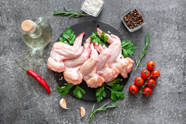 Siyah arka planda malzemeli çiğ tavuk kanadı.