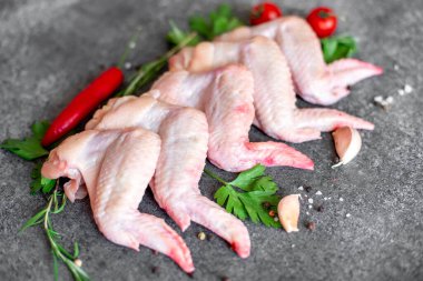 Siyah arka planda malzemeli çiğ tavuk kanadı.