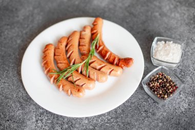 Biberiyeli domuz sosisi ve siyah arka planda baharatlar.