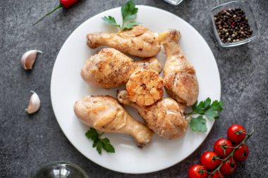 Pişmiş tavuk budu, sebze ve baharatlı beyaz tabak.