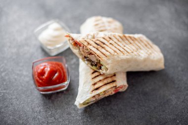 Gri arka planda tavuk ve sebzeli Shawarma sandviçi