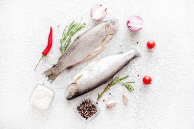 Beyaz taş arka planda yemek pişirmek için malzemeli çiğ alabalık.