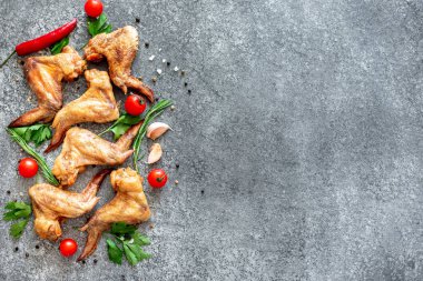 Siyah taş arka planda baharatlı ve otlu ızgara tavuk kanadı
