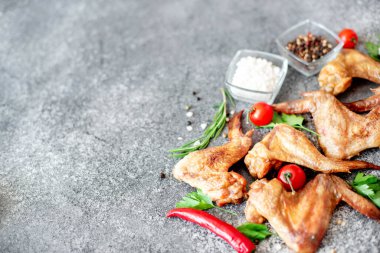 Siyah taş arka planda baharatlı ve otlu ızgara tavuk kanadı