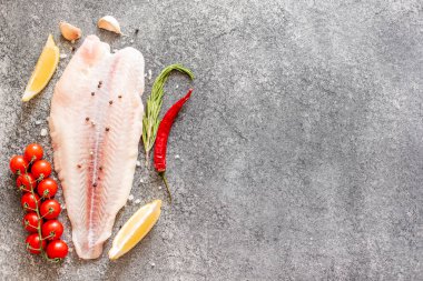 Arkaplanda baharatlar olan çiğ balık filetosu.