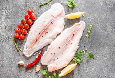 Arkaplanda baharatlar olan çiğ balık filetosu.