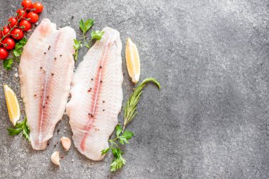 Arkaplanda baharatlar olan çiğ balık filetosu.