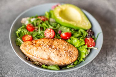 Avokado ve sebze salatalı ızgara somon bifteği.