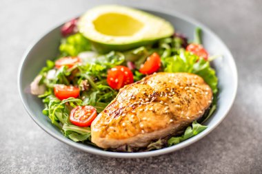 Avokado ve sebze salatalı ızgara somon bifteği.