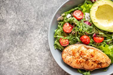 Avokado ve sebze salatalı ızgara somon bifteği.