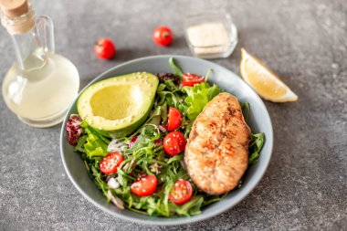 Avokado ve sebze salatalı ızgara somon bifteği.