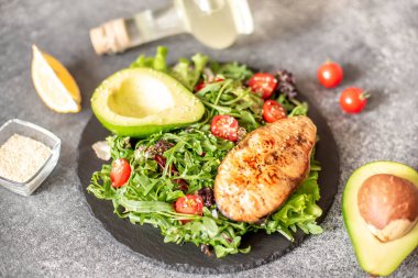 Avokado ve sebze salatalı ızgara somon bifteği.