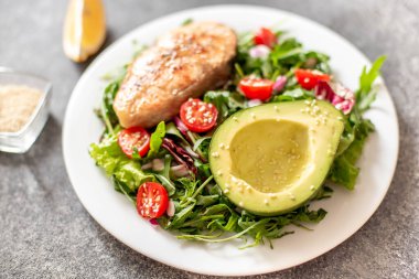 Avokado ve sebze salatalı ızgara somon bifteği.