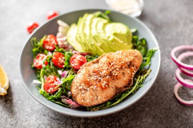 Avokado ve sebze salatalı ızgara somon bifteği.