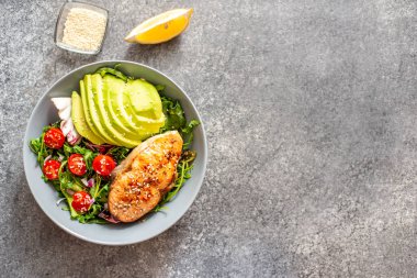 Avokado ve sebze salatalı ızgara somon bifteği.