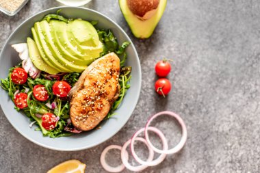 Avokado ve sebze salatalı ızgara somon bifteği.